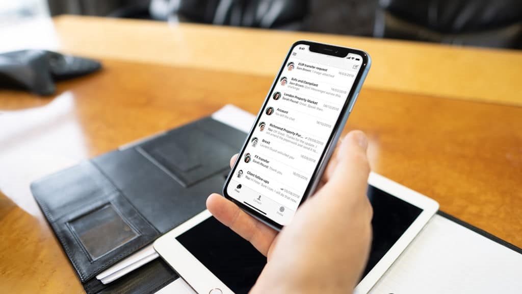 Image showing a hand holding a phone with Qwil Messenger open